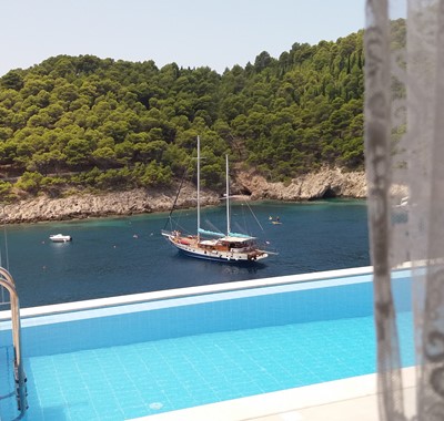 View from inside Villa Panorama looking out into the bay with yacht and private pool