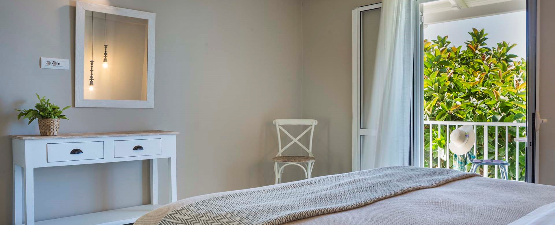 Double bed and French doors onto the balcony with views of the sea at Beachfront Suite No4, Lourdata, Kefalonia