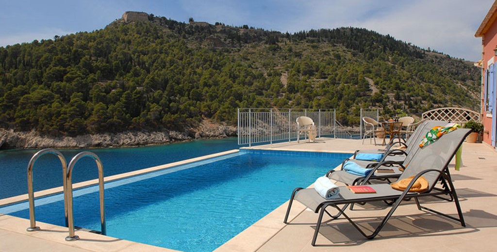 Infinity pool, sun loungers and view of the hill outside Villa Panorama, Assos, Kefalonia