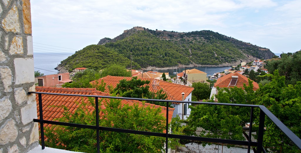 View over the rooftops toward the sea and ruined Venetian fort outside Villa Vivere, Assos, Kefalonia