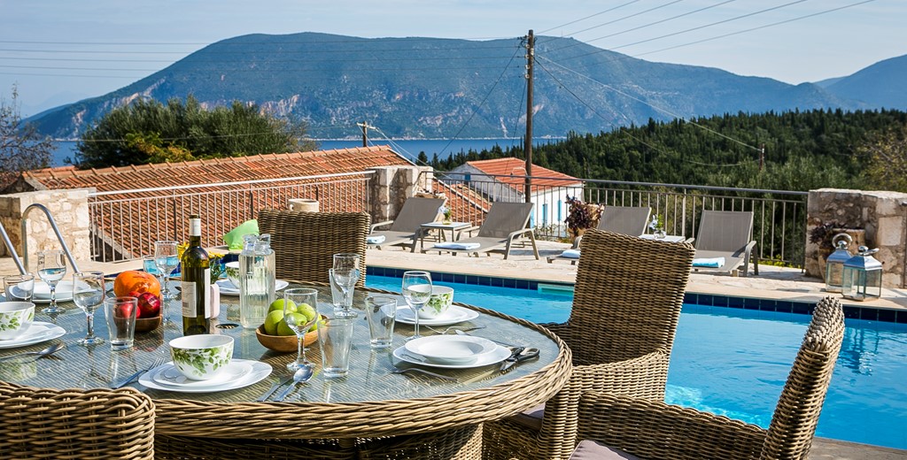 Al fresco dining beside the pool with a view of the cost and mountains outside Villa Pelagia, Fiscardo, Kefalonia, Greek Islands